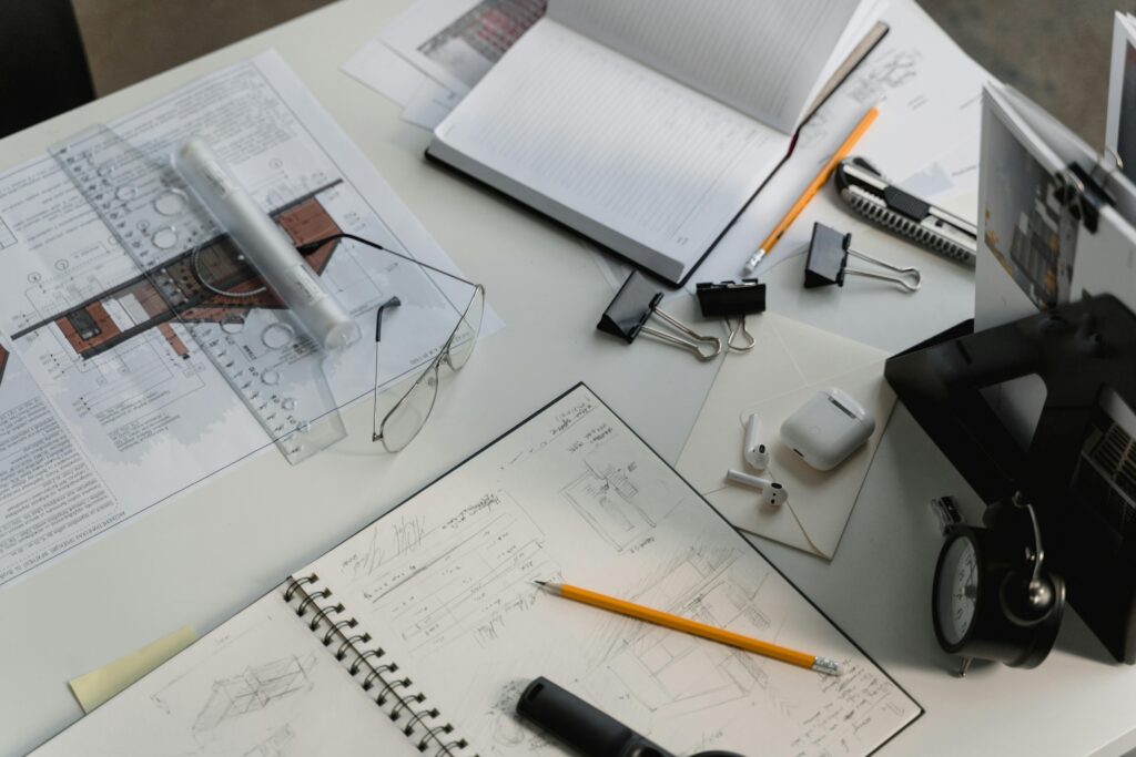 Automatización de Procesos A busy architectural workspace featuring blueprints, sketches, and drafting tools.